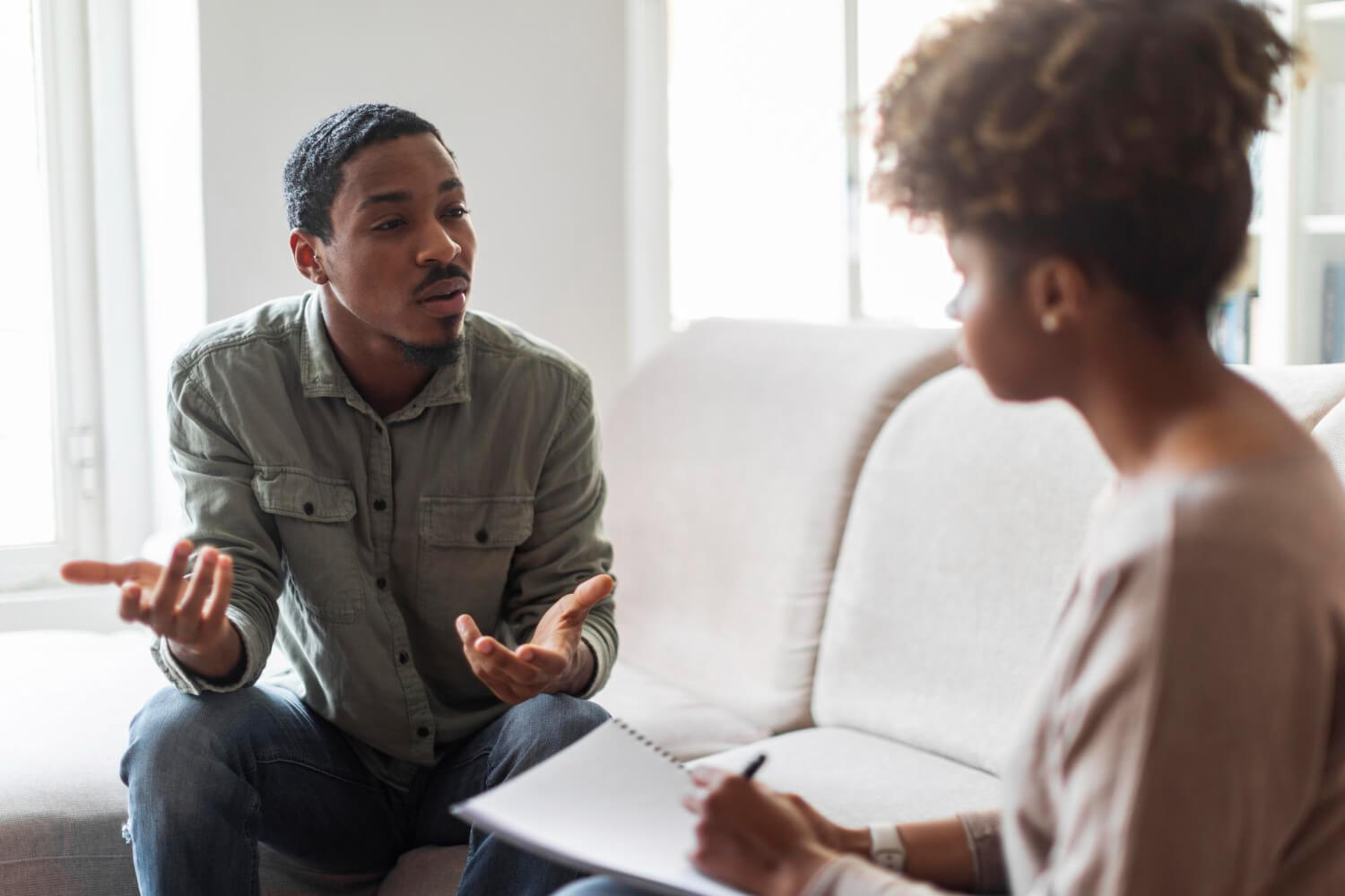 unhappy-black-man-attending-therapy-session-with-psychologist (1)